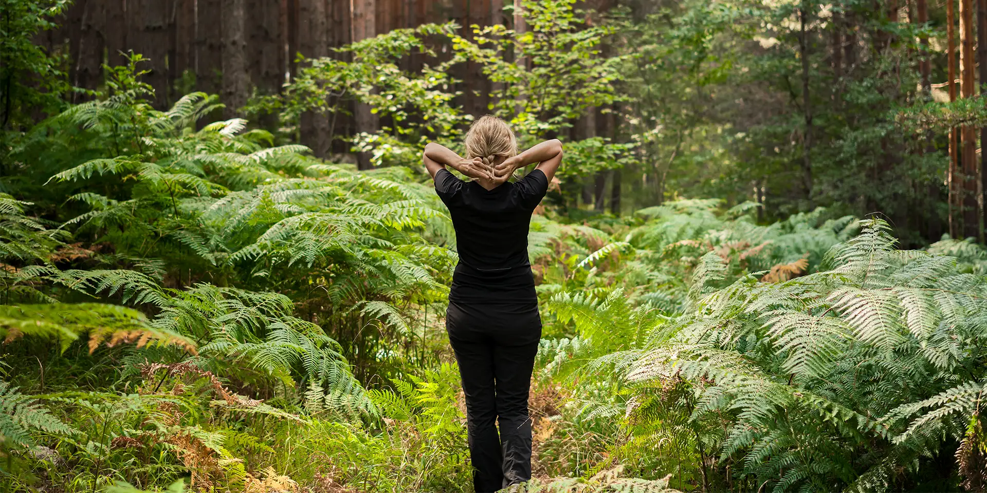 Frau steht im Wald