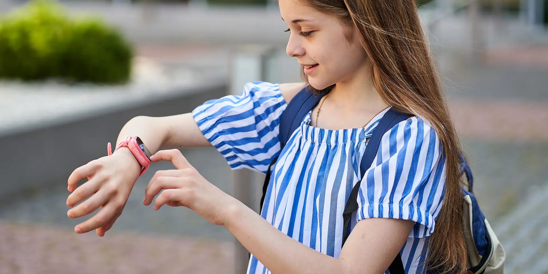 Maedchen schaut auf Smartwatch